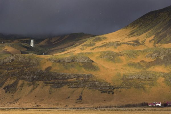 Paysage du sud de l'Islande qui illustre bien la météo : un ciel couvert mais un rayon de soleil qui illumine la montagne