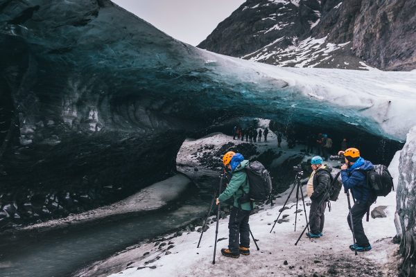 Photographes au bord d'une grotte de glace en Islande