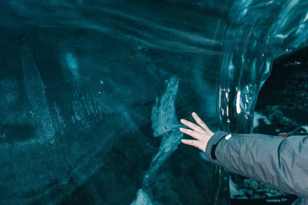 Toucher la paroi d'une grotte de glace en Islande
